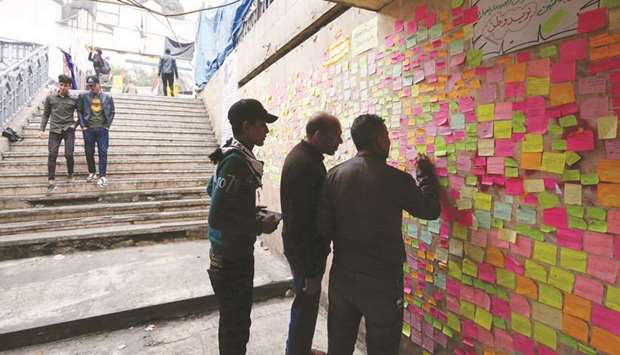 Iraqi protesters write their wishes on notes in Tahrir square in the capital Baghdad, yesterday, amid ongoing anti-government demonstrations.