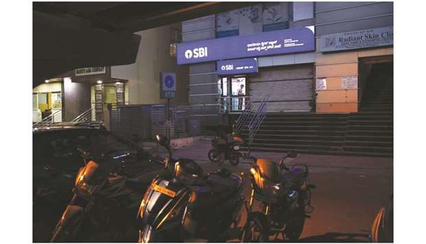 A customer uses an automated teller machine at a State Bank of India branch at night in Bengaluru. Indian banks, including SBI, are expected to benefit from the recovery process from four failed companies u2013 Essar Steel India, Prayagraj Power Generation Co, Ruchi Soya Industries and RattanIndia Power u2013 which should be completed in  December, according to sources.