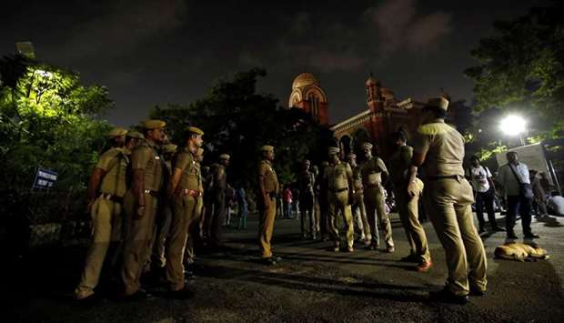 Police stand guard inside a Madras university compound during a protest by the university students against a new citizenship law and to show solidarity with the students of New Delhi's Jamia Millia Islamia university after police entered the university campus on Sunday, following a protest against the new law, in Chennai, India