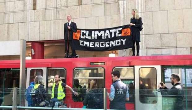 Climate protesters with the Extinction Rebellion group climb on top of a train at London's Canary Wharf station