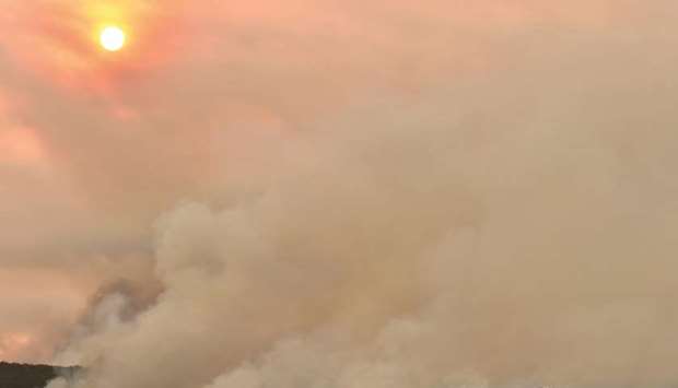A helicopter drops water onto a large bushfire in Bargo, 150km southwest of Sydney yesterday.