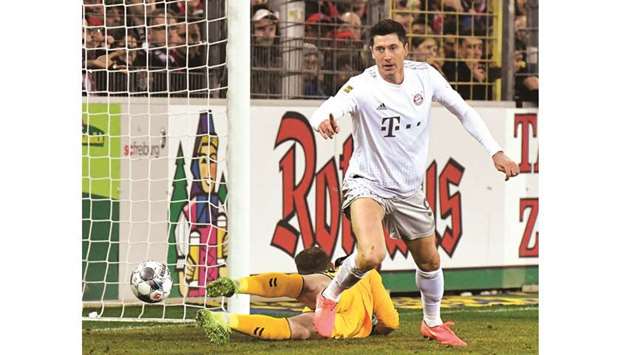 Bayern Munichu2019s Polish forward Robert Lewandowski (R) reacts after scoring against SC Freiburg on December 18.
