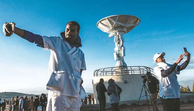 People take selfie pictures in front of a satellite antenna during the ceremony for the launching of the Ethiopian Remote Sensing Satellite (ETRSS) in Entoto Observatory and Research Centre in Addis Ababa, yesterday.