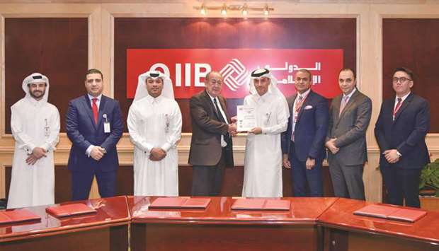 Al-Jamal (fourth right) and other senior executives at an event held at QIIB headquarters on Grand Hamad street in Doha, where the bank was awarded the ISO 27001 certification, one of the worldu2019s most prestigious accreditation in information security.