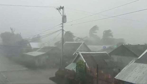 Trees sway near buildings as Typhoon Kammuri, known locally as Typhoon Tisoy, makes landfall in Gamay, Northern Samar, Philippines