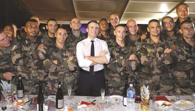 French President Emmanuel Macron celebrates his 42nd birthday with French soldiers from the Foreign Legion 2e REP regiment during a Christmas dinner with troops at the Port-Bouet military camp near Abidjan, yesterday.