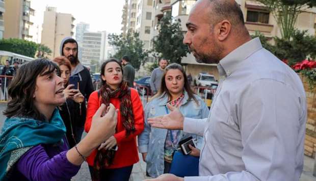 Lebanese anti-government demonstrators (L) argue with a representative of the popular movement (R), outside the home of Lebanon's prime-minister designate, in the neighbourhood of Tallet al-Khayat in the Lebanese capital Beirut