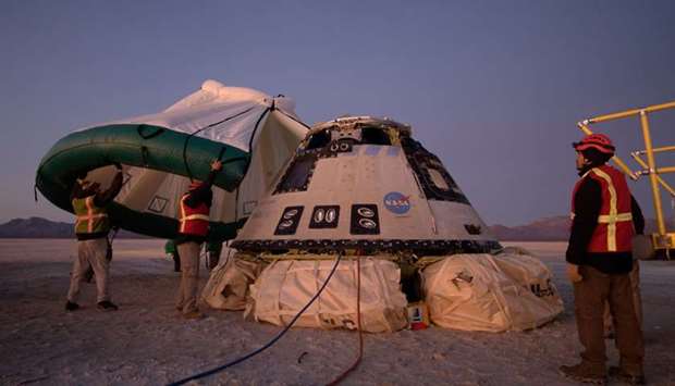 A protective tent is placed over the Boeing CST-100 Starliner spacecraft, which had been launched on a United Launch Alliance Atlas V rocket, after its descent by parachute following an abbreviated Orbital Flight Test for NASAu2019s Commercial Crew programs in White Sands, New Mexico, US. NASA/Bill Ingalls via REUTERS
