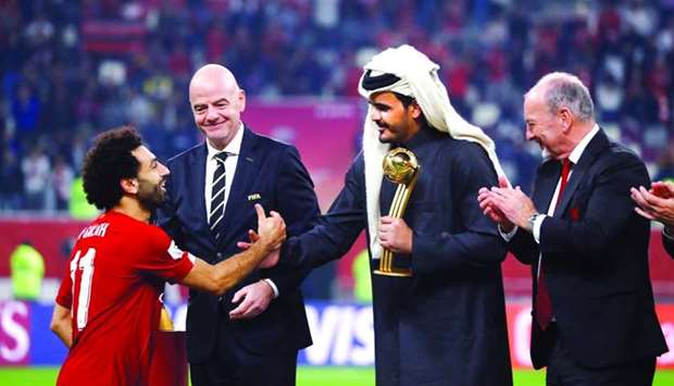 Liverpool's Mohamed Salah is presented the Golden Ball award by Qatar Olympic Committee president HE Sheikh Joaan bin Hamad al-Thani as Liverpool CEO Peter Moore applauds and FIFA president Gianni Infantino looks on.