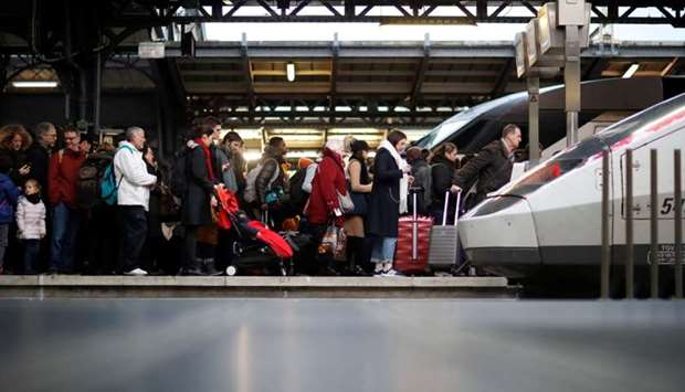 Commuters walk on a platform at Gare de l'Est train station during a strike by all unions of French SNCF and the Paris transport network (RATP) in Paris as French transportation workers' strike continues for a 19th day against pension reform plans in France