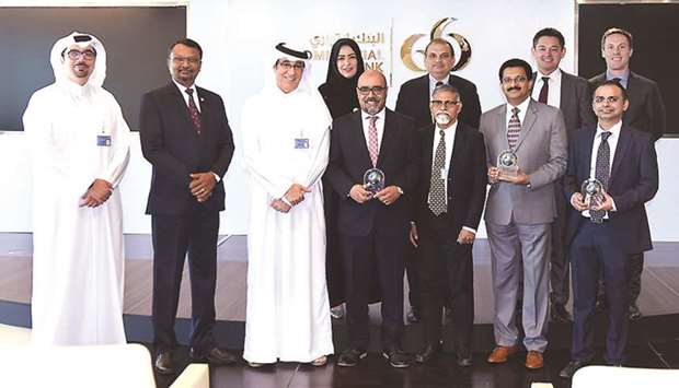 Senior Commercial Bank executives with the awards won by the bank in recognition of its leading digital services in the local market.