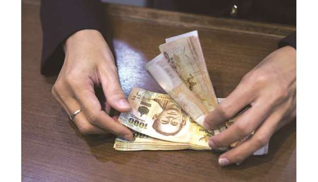 An employee counts Thai  one-thousand baht banknotes at a bank branch in Bangkok. The currency has climbed just 0.2% in December, making it among Asiau2019s worst-performing currencies.