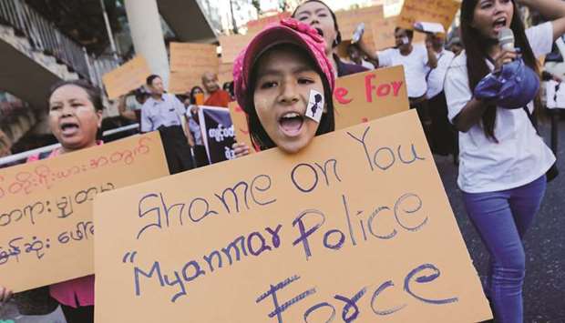 A protester holds up a placard demanding justice for Victoria, an alleged victim of child abuse, in Yangon yesterday.