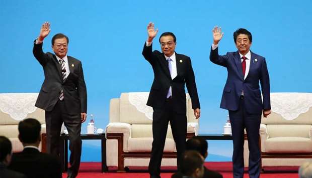 (From left) South Korea's President Moon Jae-in, Chinese Premier Li Keqiang and Japanese Prime Minister Shinzo Abe wave at the beginning of the trilateral business meeting between China, South Korea and Japan in Chengdu