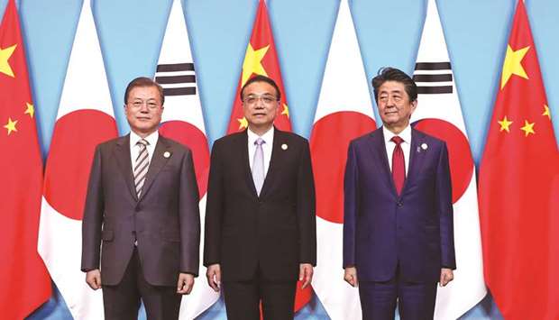 Chinau2019s Premier Li Keqiang, Japanu2019s Prime Minister Shinzo Abe and South Koreau2019s President Moon Jae-in pose for pictures ahead of the 8th trilateral leadersu2019 meeting in Chengdu, Sichuan province, China yesterday.