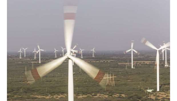 Wind turbines and electricity pylons stand at the Suzlon Energyu2019s Nani Sindhodi wind farm in Kutch, India. The Indian wind turbine maker hasnu2019t secured the credit rating it needs to present a restructuring offer to creditors, who must approve a recast plan before January 7 or tip Suzlon into bankruptcy to avoid punitive provisions, said a person familiar with the matter.