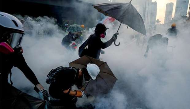 Anti-government protesters protect themselves with umbrellas against tear gas during a demonstration in Hong Kong