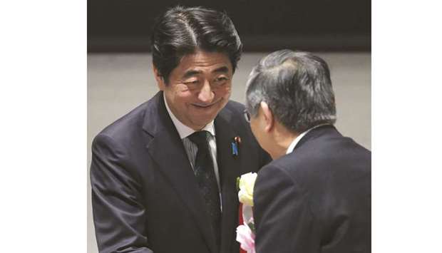 Shinzo Abe, Japanu2019s prime minister (left), shakes hands with Haruhiko Kuroda, governor of the Bank of Japan, at a  meeting in Tokyo. u201cWhatu2019s  important is investing in  people,u201d Abe said. u201cSince Iu2019ve been mentioning this every year, Iu2019ll refrain from emphasising it too much but I have high hopes for next year.u201d