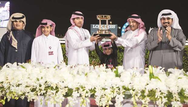 Al Shahania Stud director Abdul Rahman al-Mansour (second from right) presents the trophy to the winning connections in the presence of Qatar Racing and Equestrian Club CEO Nasser Sherida al-Kaabi (right) after Al Wasmiyah Farmu2019s Noor Al Hawa won the His Highness Sheikh Mohamed bin Khalifa al-Thani Trophy (QA Group 2) at the Al Rayyan Park yesterday. PICTURES: Juhaim