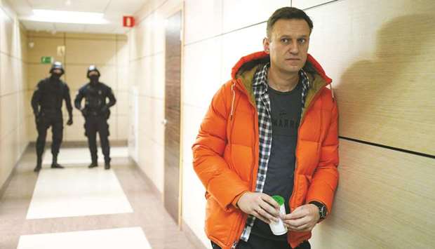 Navalny stands near law enforcement agents in a hallway of a business centre, which houses the office of his Anti-Corruption Foundation (FBK), in Moscow.