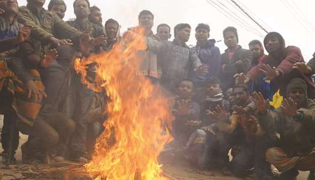 People gather around a fire during a winter morning in Dhaka.