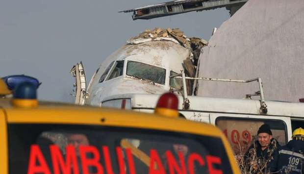 Emergency personnel are seen at the site of a plane crash near Almaty yesterday