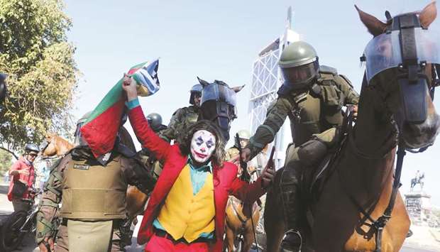 Members of the security forces hold a man dressed as a clown during a protest against Chileu2019s government in Santiago, Chile.
