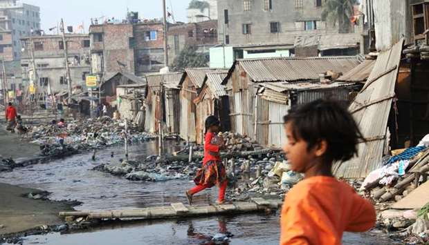 A girl, who lives in polluted environment in a slum, carries a water bottle in Dhaka, Bangladesh