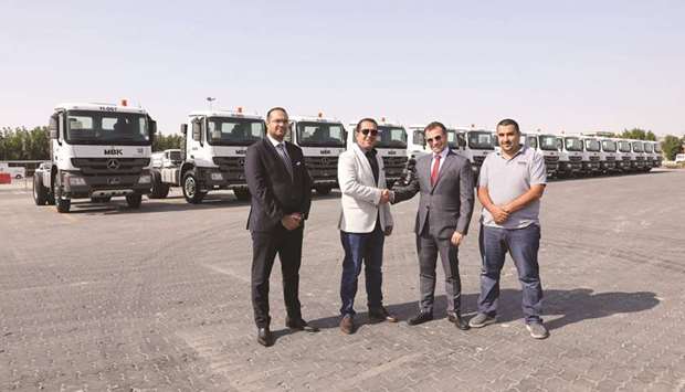 Officials of NBK Automobiles and HBK Contracting Company announce the deal.