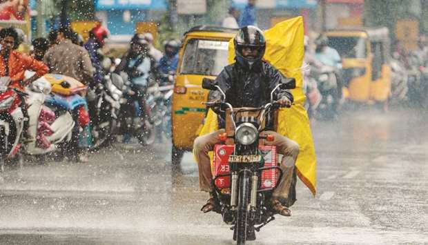 A motorist rides on a road during heavy rain in Chennai yesterday.