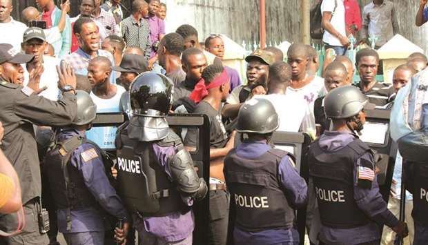 Supporters of the Council of Patriots (CoP) confront policemen in Monrovia, yesterday.