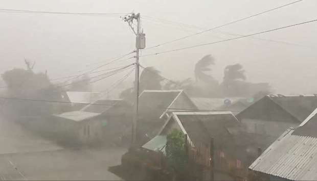 Trees sway near buildings as Typhoon Kammuri makes landfall in Gamay, northern Samar, yesterday, in this still image from video obtained via social media.