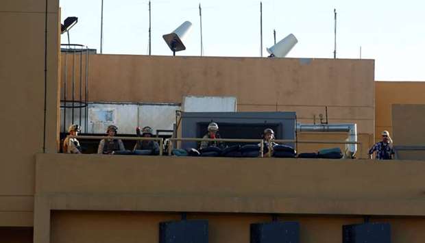 US soldiers take their position on the roof of the US Embassy during a protest to condemn air strikes on bases belonging to Hashd al-Shaabi (paramilitary forces), in Baghdad