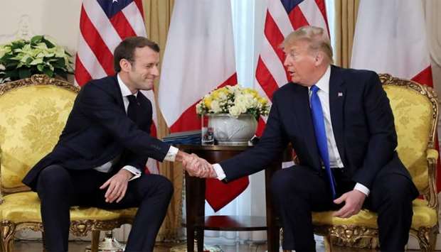 US President Donald Trump and France's President Emmanuel Macron shake hands during their meeting at Winfield House, London