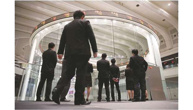 Visitors watch share prices at the Tokyo Stock Exchange in Japan. The Nikkei 225 closed down 0.6% to 23,379.81 points yesterday.
