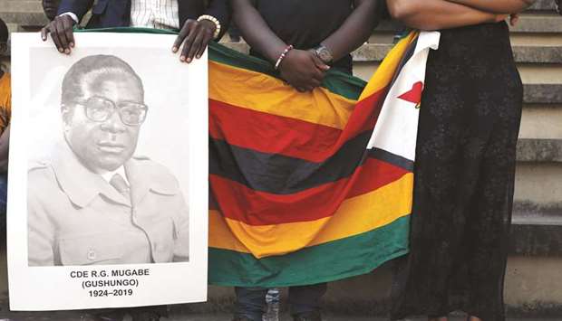 Mourners hold a poster during the state funeral of Zimbabweu2019s longtime ruler Robert Mugabe at a national sports stadium in Harare in a file picture.
