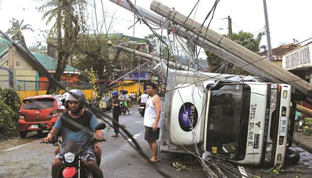 Residents are seen after Typhoon Kammuri hit Camalig town, yesterday.