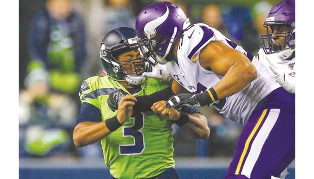 In this file photo taken on December 2, 2019 Quarterback Russell Wilson (3) of the Seattle Seahawks is pressured by linebacker Anthony Barr (55) of the Minnesota Vikings after throwing a pass in the fourth quarter at CenturyLink Field in Seattle, Washington. (AFP)
