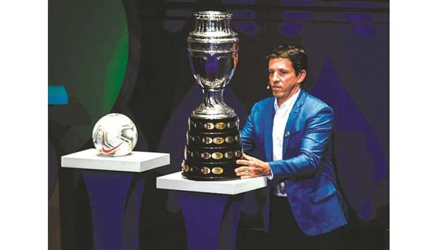 Former Brazilian footballer Juninho Paulista places the Copa America trophy on the stage during the draw for the Copa America 2020 at the Convention Centre in Cartagena, Colombia, on Tuesday. (AFP)