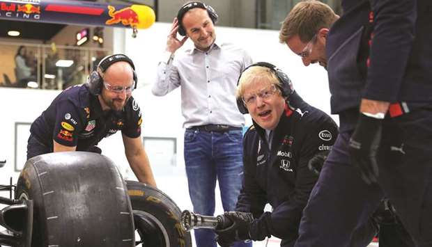 Prime Minister Boris Johnson changes a wheel of a Formula One (F1) race car during a Conservative Party general election campaign visit to Red Bull Racing in Milton Keynes, north of London, yesterday.