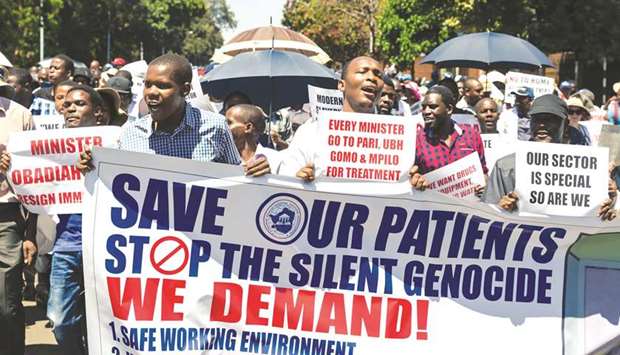 Doctors hold banners during a protest march in Harare, yesterday.
