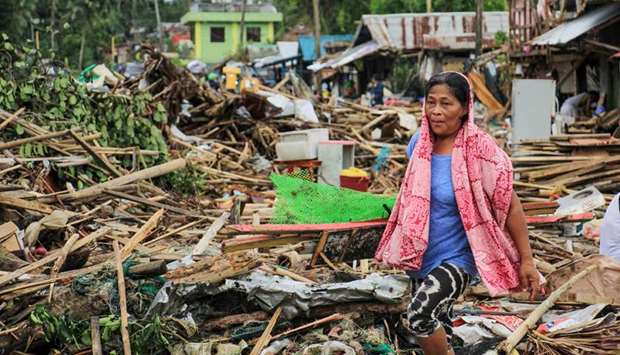 A resident walks past debris of destroyed houses after Typhoon Kammuri hit the city of Sorsogon, south of Manila.