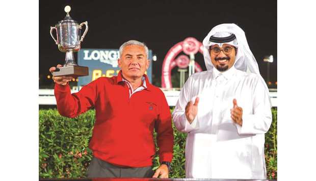 Trainer George Mikhaldes (left) receives the trophy from QREC CEO Nasser Sherida al-Kaabi after Noor Al Hawa won the Al Safliya Cup yesterday. PICTURES: Juhaim