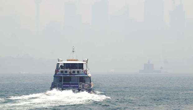 A ferry makes its way from Taronga Zoo to Circular Quay, with the CBD skyline barely visible in the background through smoke haze from bushfires, in Sydney Harbour, Australia, yesterday.