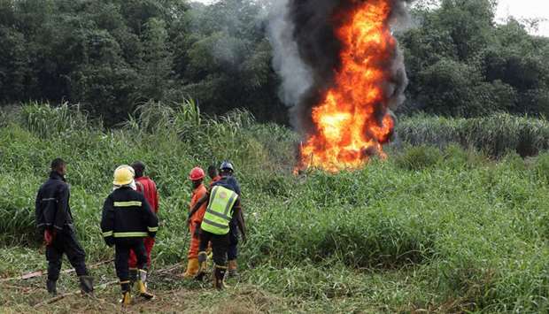 Firefighters and safety officers are seen in the Lagos swamp of Baruwa, where a burst oil pipeline is burning.