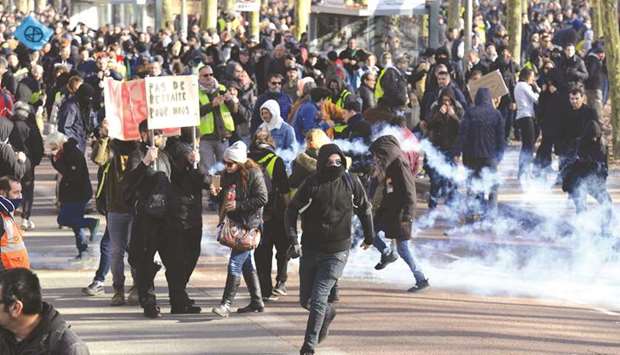 Protesters run to avoid tear gas smoke during a demonstration in Bordeaux against the governmentu2019s pension reform.