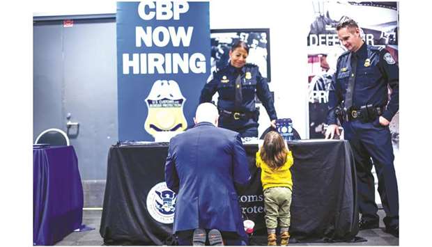 A job seeker with a child speaks with US Customs and Border Protection (CBP) representatives during a job fair in Detroit. Nonfarm payrolls increased by 266,000 jobs last month, with manufacturing recouping all the 43,000 positions lost in October, the governmentu2019s survey of establishments showed yesterday.