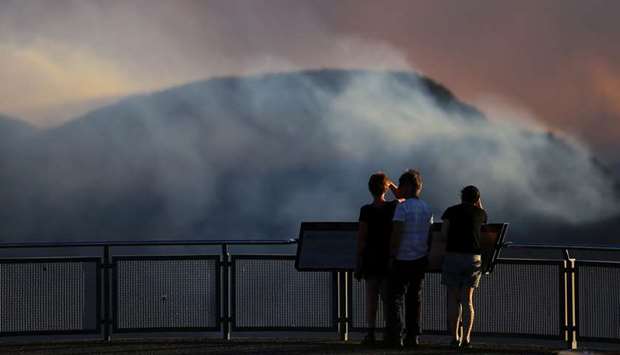 People watch as smoke from the Green Wattle Creek fire is seen from Echo Point lookout in Katoomba, New South Wales, Australia, yesterday.