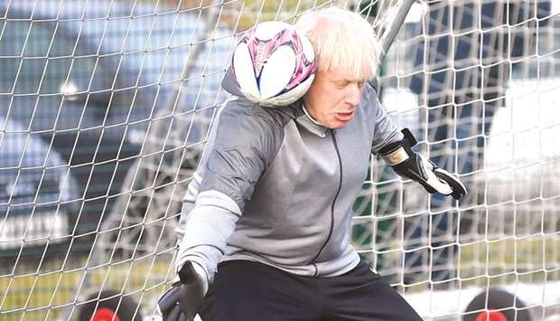 Prime Minister Boris Johnson tries to save a shot during a warm up before a girlsu2019 football match while on the campaign trail in Cheadle Hulme, northwest England yesterday.