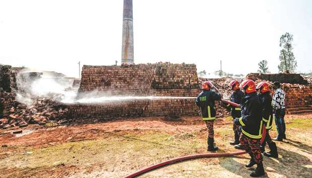 Firefighters spray water over a brick kiln as local authorities prepare to demolish illegal brick kiln on the outskirts of Dhaka yesterday.